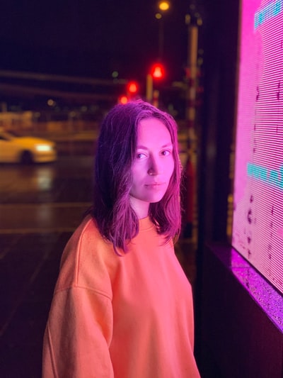 Women wearing orange sweatshirt stood in front of the LED wall
